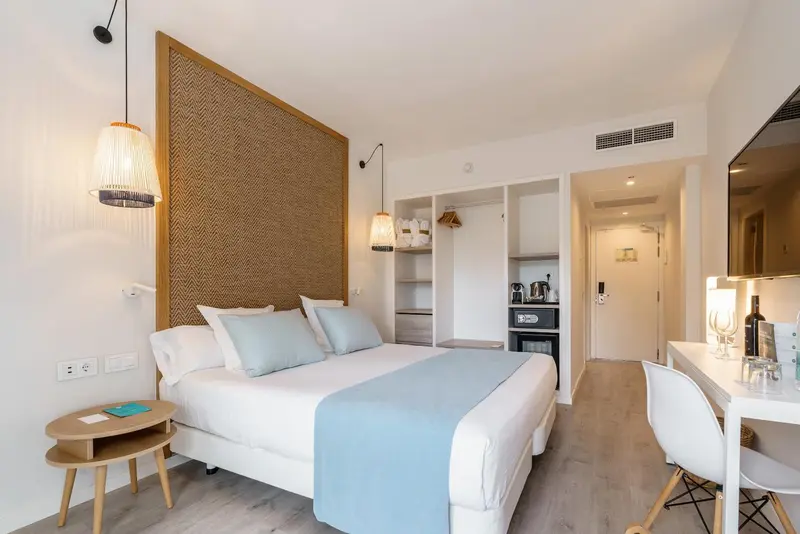 Une chambre lumineuse avec un grand lit et un bureau.