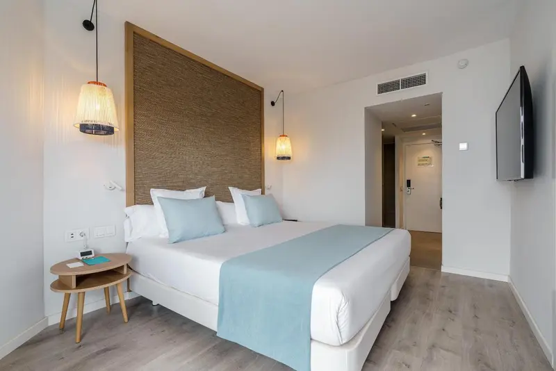 Une chambre lumineuse avec un grand lit et une décoration sobre.