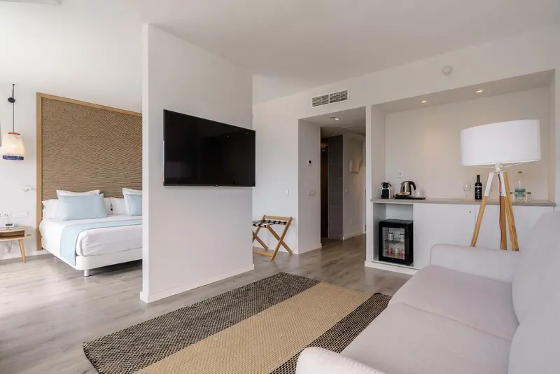 Une chambre lumineuse avec un lit et un espace salon.