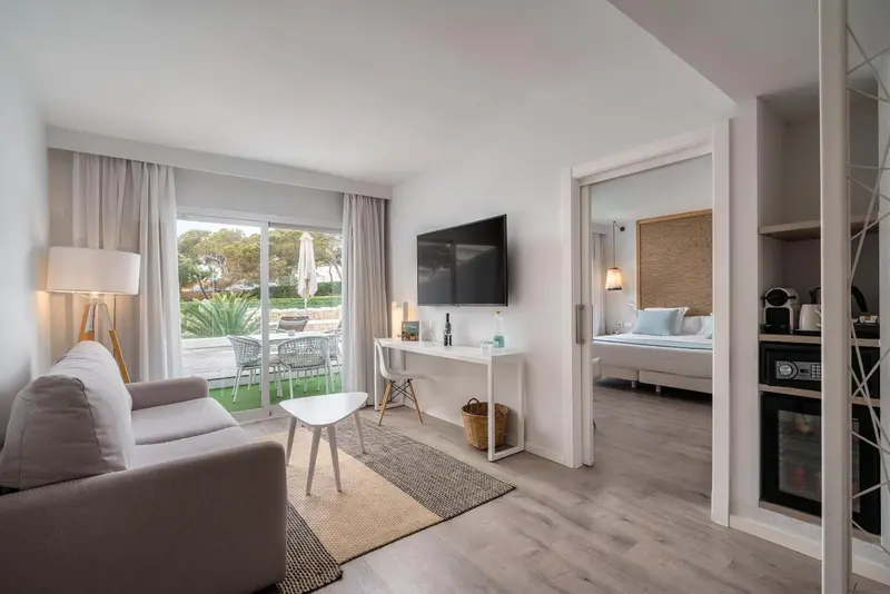 Espace de séjour lumineux avec canapé, table basse et accès à une terrasse.