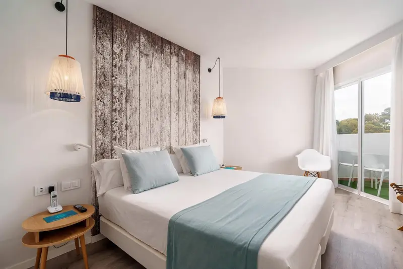 Une chambre lumineuse avec un grand lit et une décoration sobre.