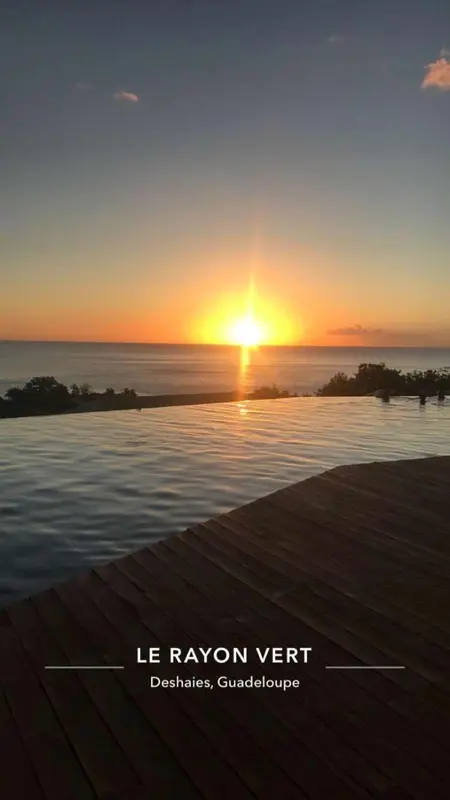 Coucher de soleil sur l'océan vu depuis une piscine à débordement.