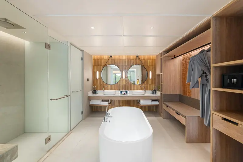 Une salle de bain lumineuse avec baignoire et double vasque.