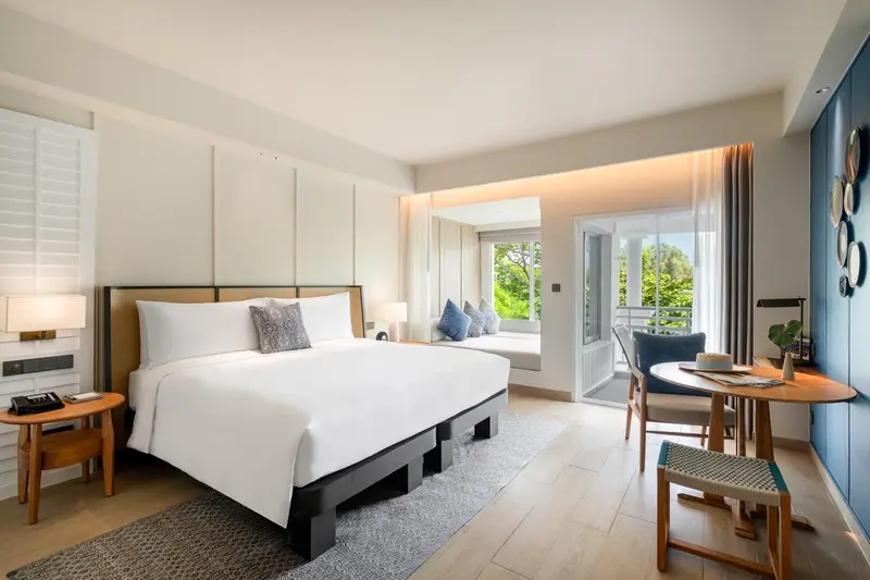 Une chambre lumineuse avec un grand lit et un coin salon.