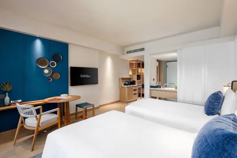 Une chambre lumineuse avec un lit double et un espace bureau.