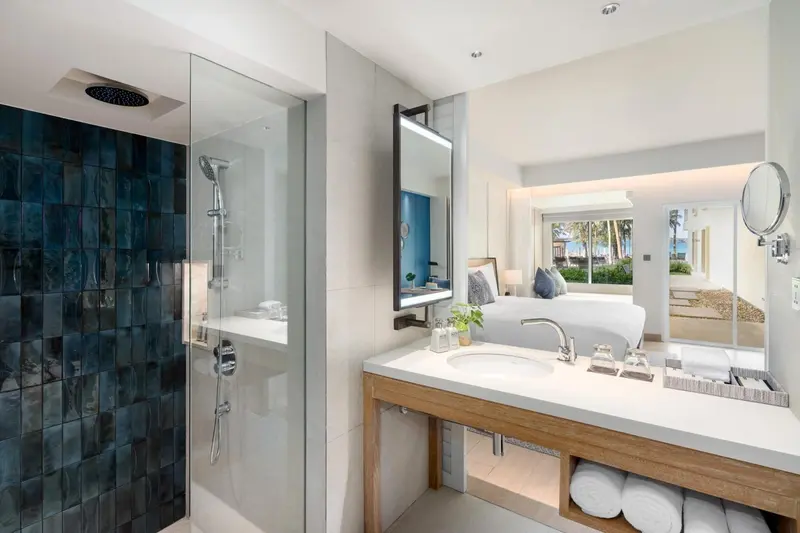 Une salle de bain lumineuse avec douche à l'italienne et vasque sur meuble.