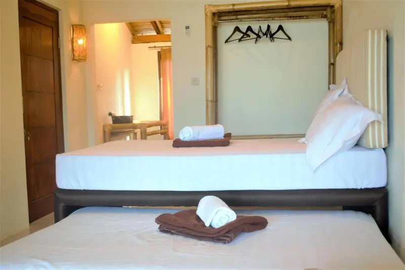 Une chambre lumineuse avec un grand lit recouvert de draps blancs.