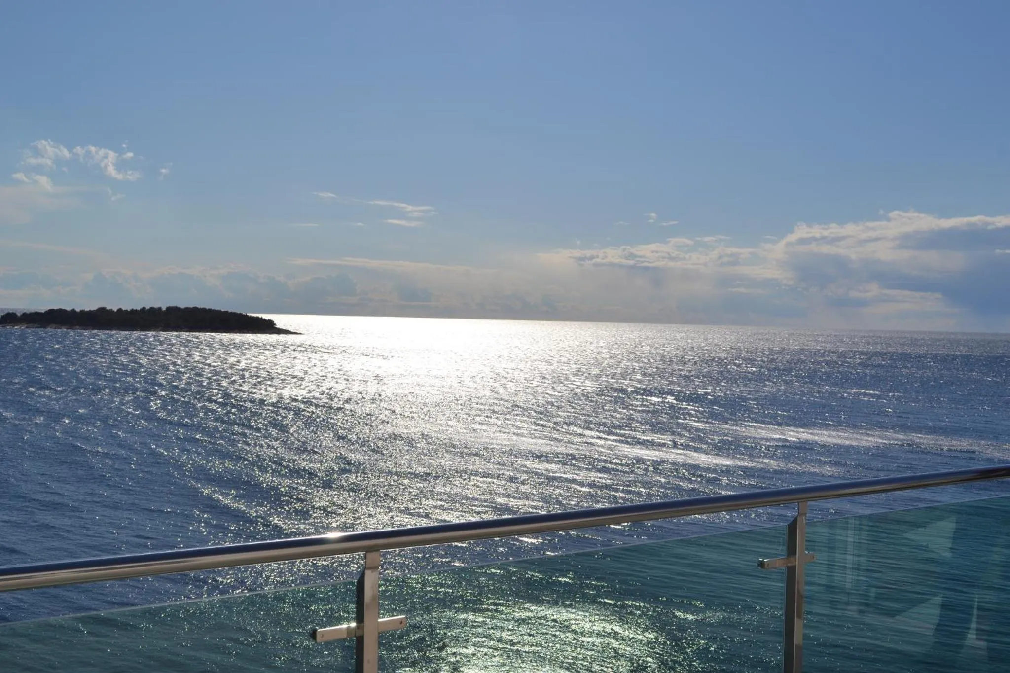 Vue sur la mer scintillante depuis une terrasse ensoleillée.