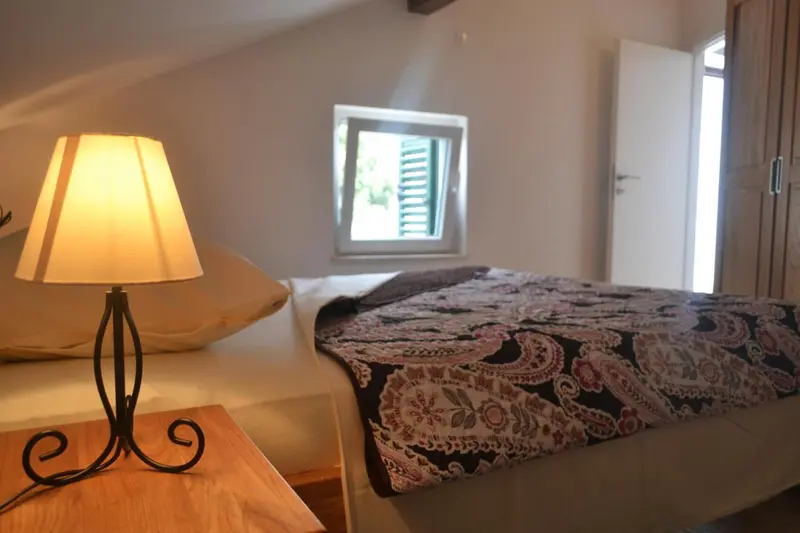 Une chambre lumineuse avec un lit recouvert d'une couverture décorative.