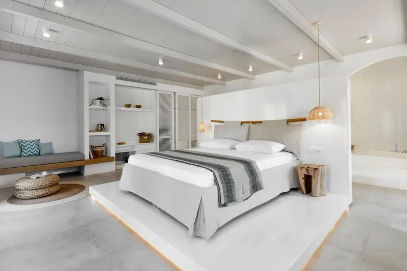 Une chambre lumineuse avec un grand lit et un espace détente.