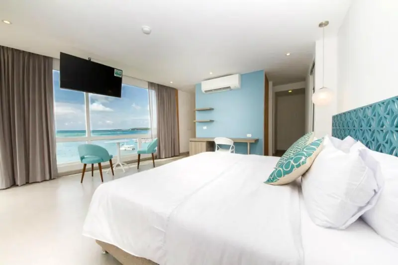 Une chambre lumineuse avec un grand lit et une vue sur la mer.