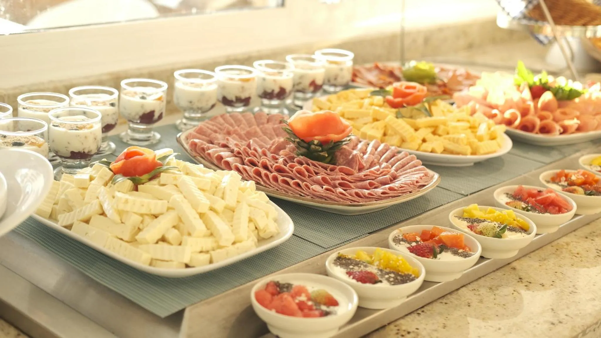 Un buffet propose une variété de charcuteries, de fromages et de fruits.