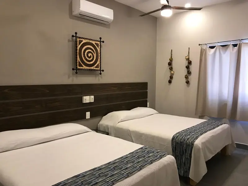 Une chambre avec deux lits simples et une décoration murale.