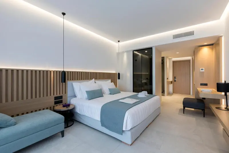Une chambre lumineuse avec un grand lit et un coin salon.