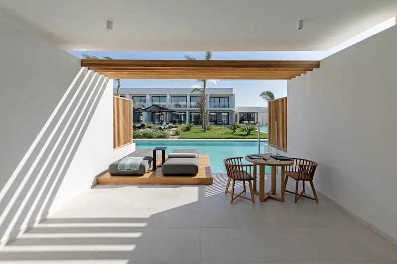 Espace de détente intérieur avec vue sur une piscine et un jardin.