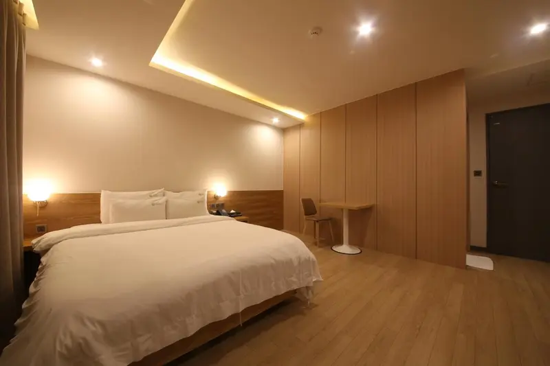 Une chambre lumineuse avec un grand lit et un coin bureau.