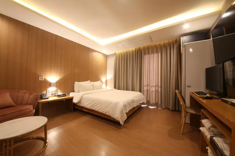 Une chambre lumineuse avec un grand lit et un coin salon.