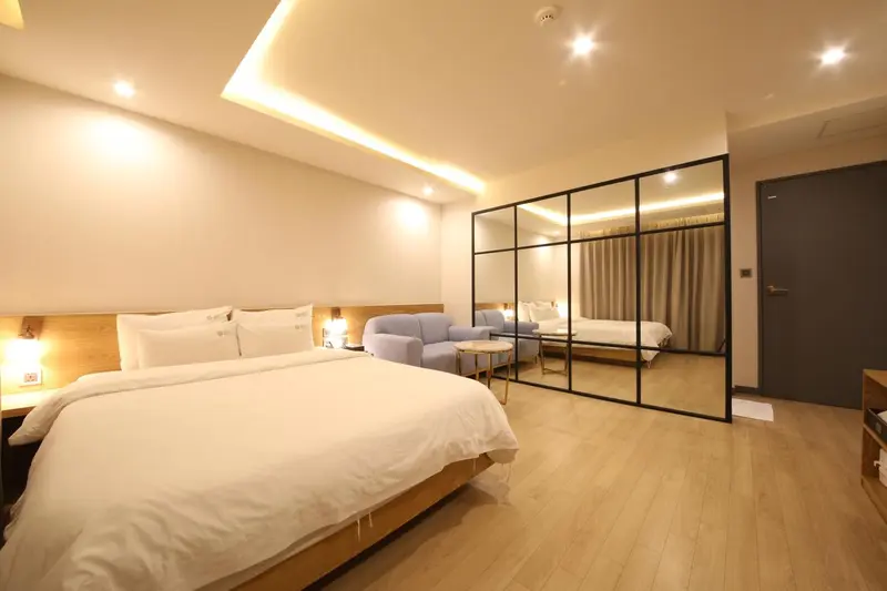 Une chambre lumineuse avec un grand lit et un canapé.