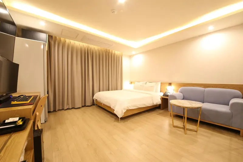 Une chambre lumineuse avec un lit double et un canapé.