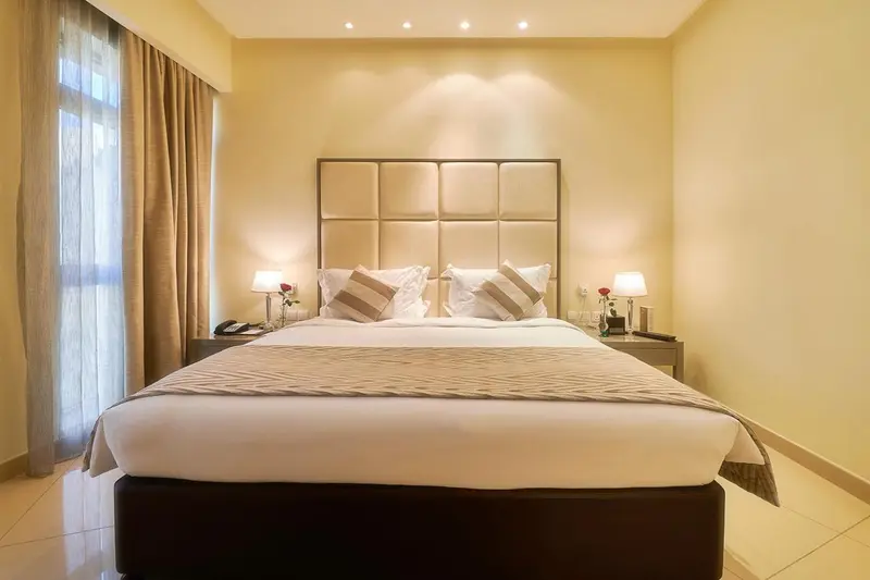 Une chambre d'hôtel lumineuse avec un grand lit et des tables de chevet.