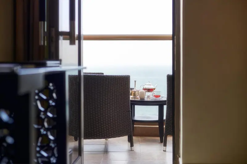 Une table basse avec une théière et des tasses sur une terrasse.