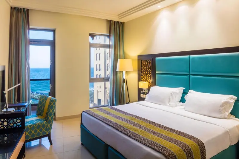 Une chambre lumineuse avec un grand lit et une vue sur la mer.
