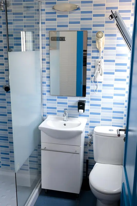 Une salle de bain moderne avec douche, lavabo et toilettes.