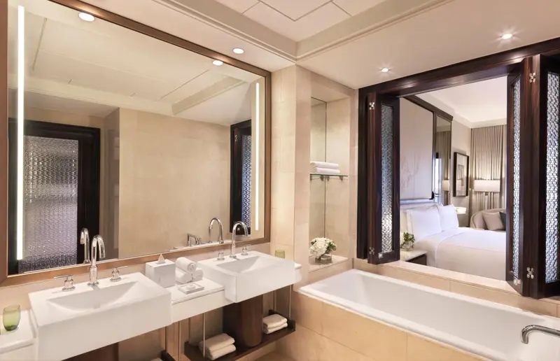 Une salle de bain lumineuse avec double vasque et baignoire.