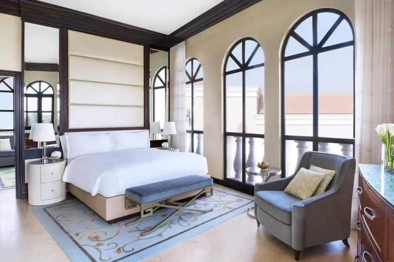 Une chambre lumineuse avec un grand lit et une vue sur l'extérieur.