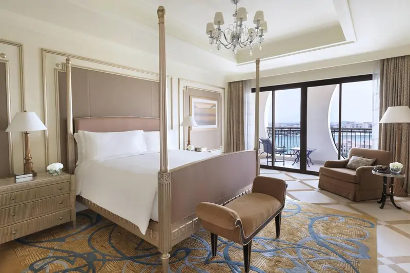 Une chambre avec un grand lit à baldaquin et un coin salon.