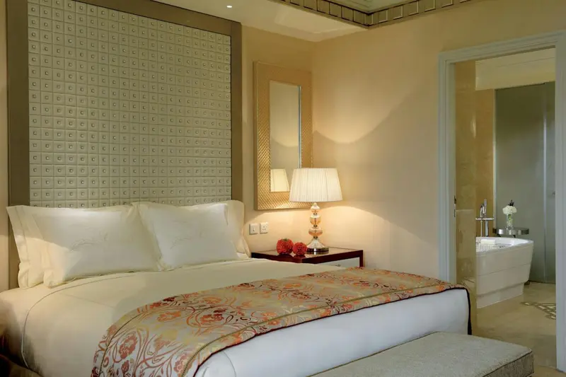 Une chambre lumineuse avec un grand lit et un accès à une salle de bain.