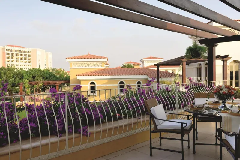 Terrasse fleurie avec mobilier de jardin et vue sur des bâtiments.