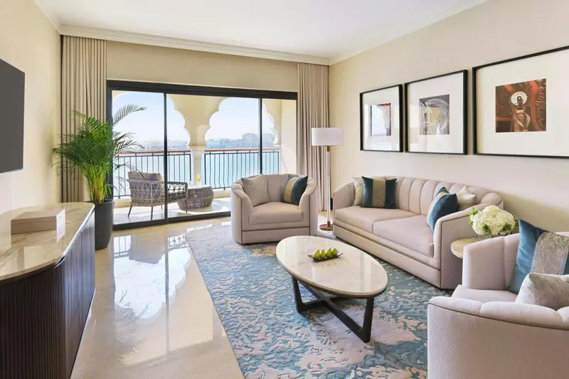 Un salon lumineux s'ouvre sur un balcon avec vue sur la mer.