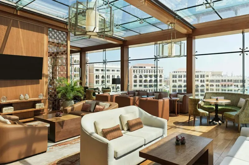 Un espace de détente intérieur avec canapés et tables basses, baigné de lumière naturelle.