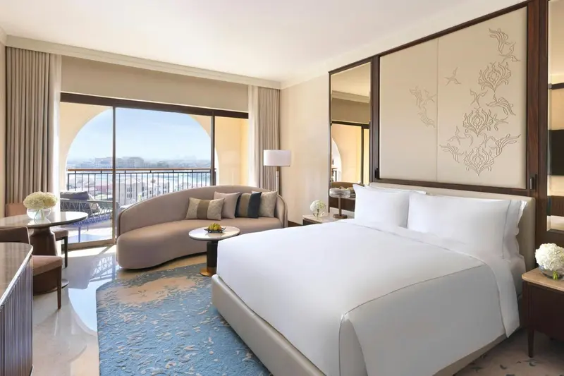 Une chambre lumineuse avec un canapé et un lit king-size.