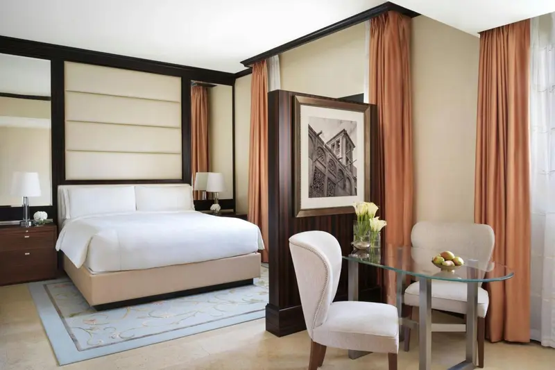 Une chambre lumineuse avec un grand lit et un coin salon.