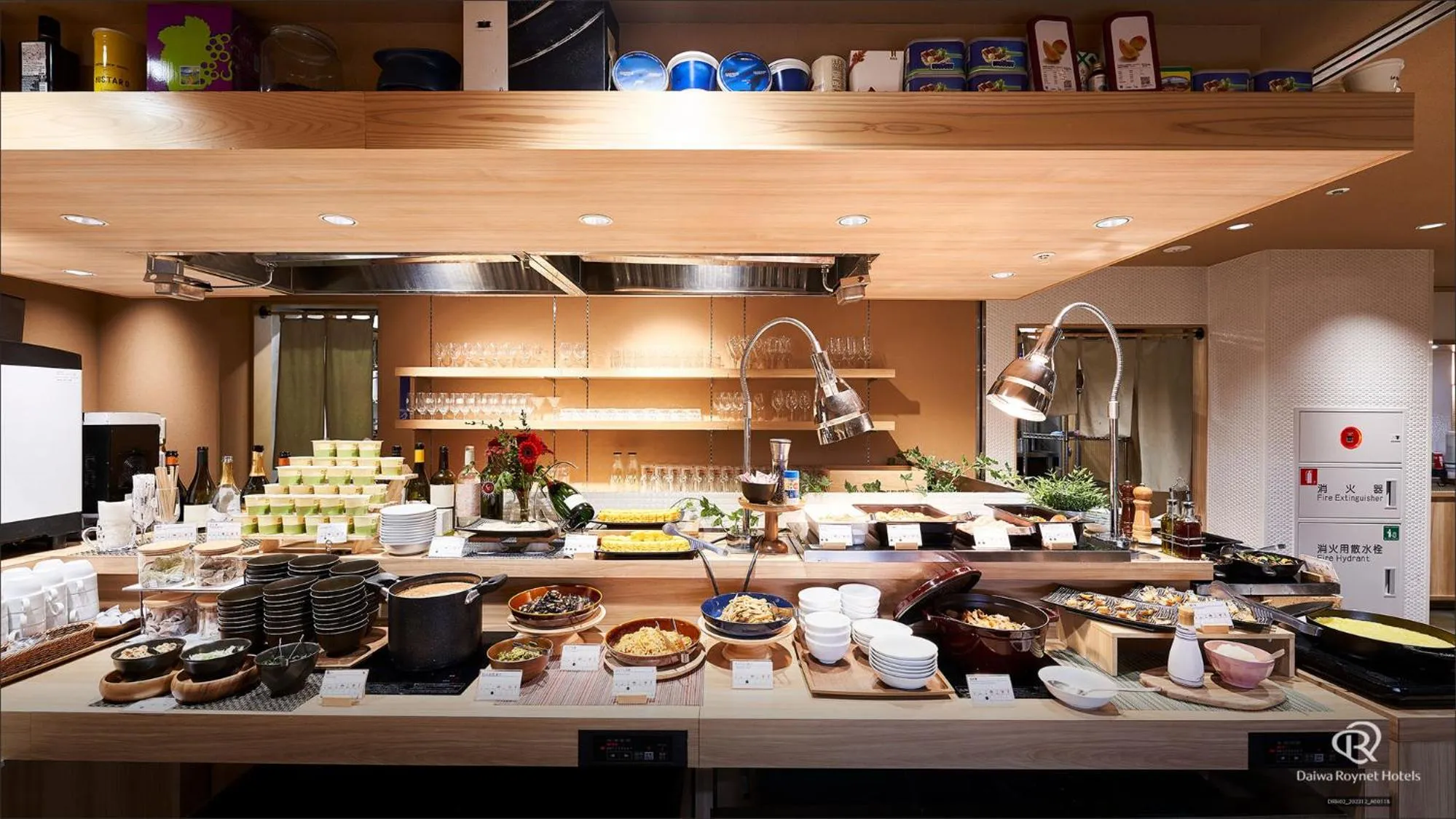 Un buffet propose une variété de plats et de boissons dans un espace lumineux.