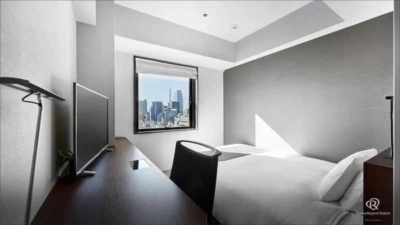 Une chambre d'hôtel moderne avec un bureau et une vue sur la ville.