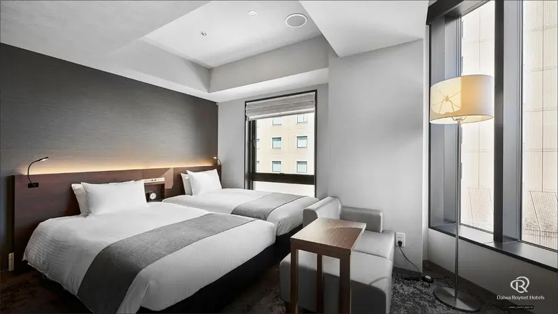 Chambre avec deux lits simples et une table de chevet.
