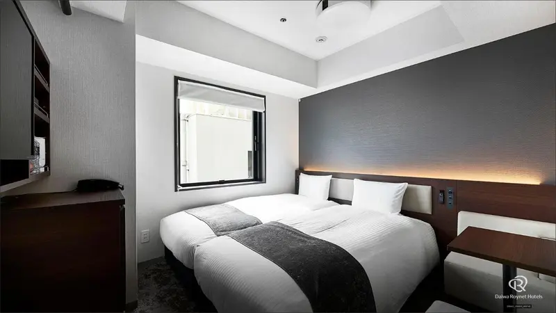 Une chambre d'hôtel moderne avec un lit double et un éclairage tamisé.