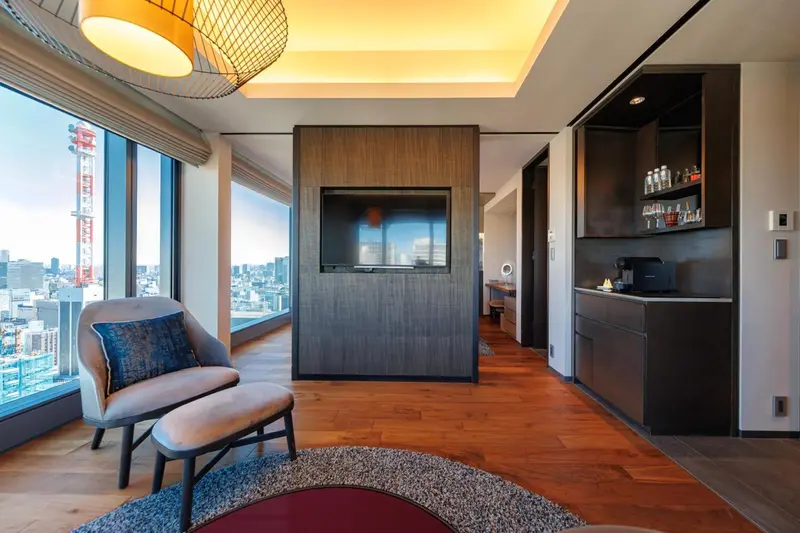 Un espace de détente intérieur avec un fauteuil et une télévision murale.