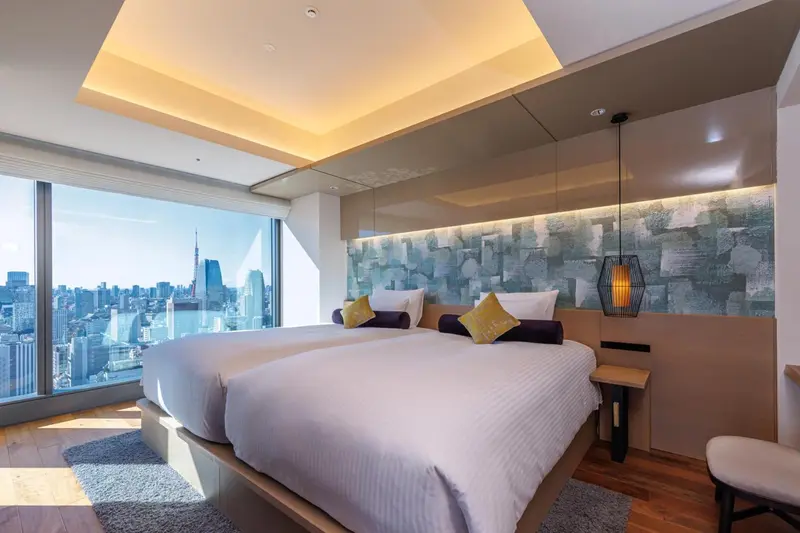 Chambre moderne avec lits jumeaux et vue sur la ville.