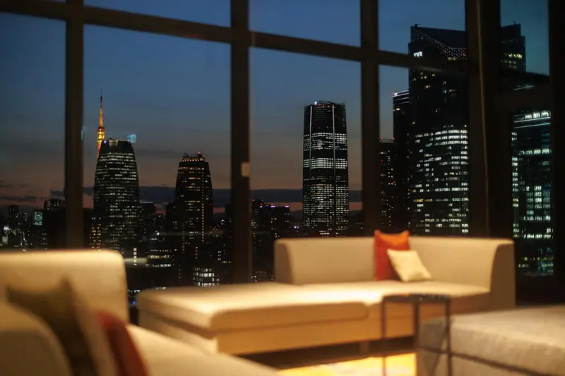 Canapés confortables face à une vue nocturne sur la ville.