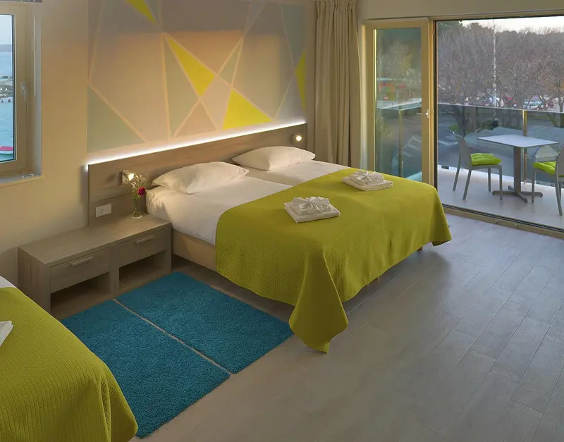 Une chambre lumineuse avec un grand lit et un accès à une terrasse.