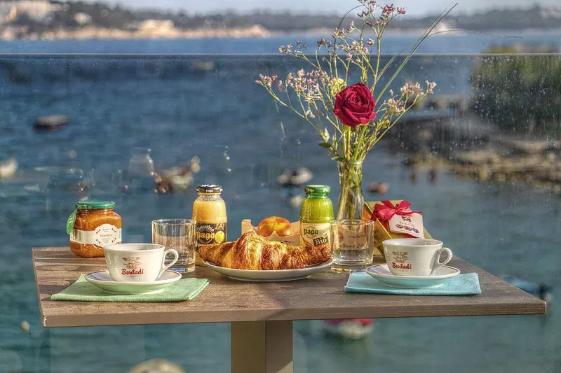 Une table est dressée avec un petit-déjeuner face à la mer.