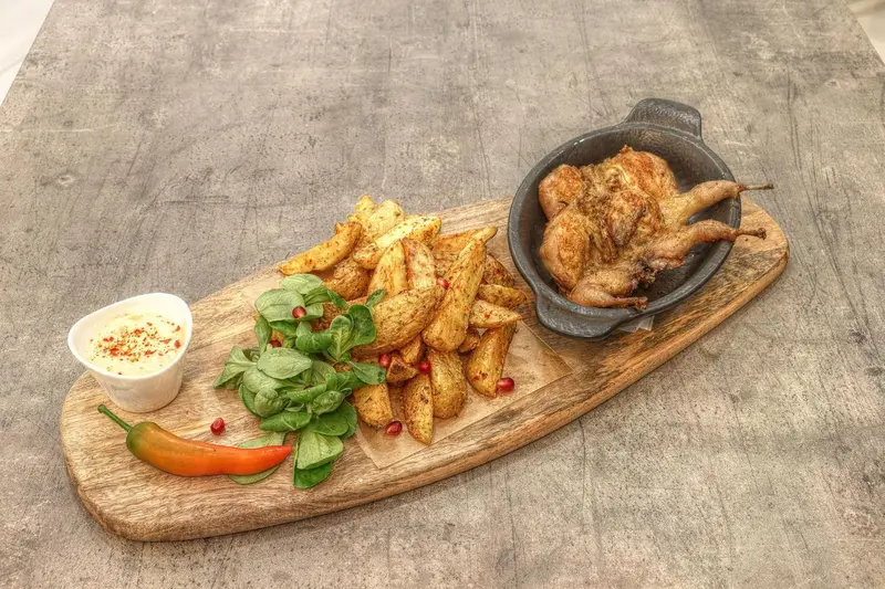 Assiette de poulet rôti accompagné de frites et d'une sauce.