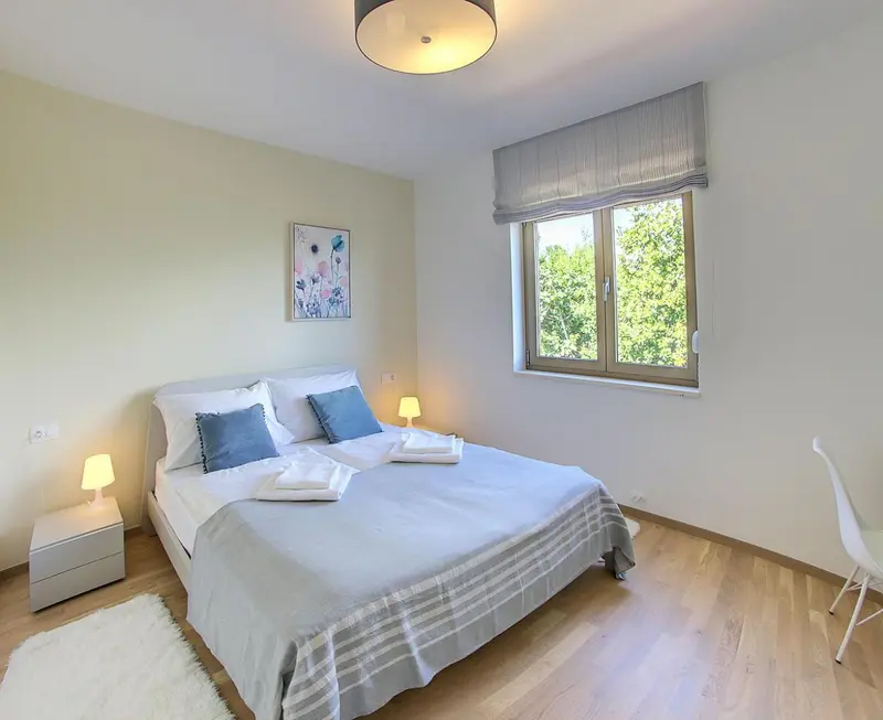Une chambre lumineuse avec un grand lit et une fenêtre.