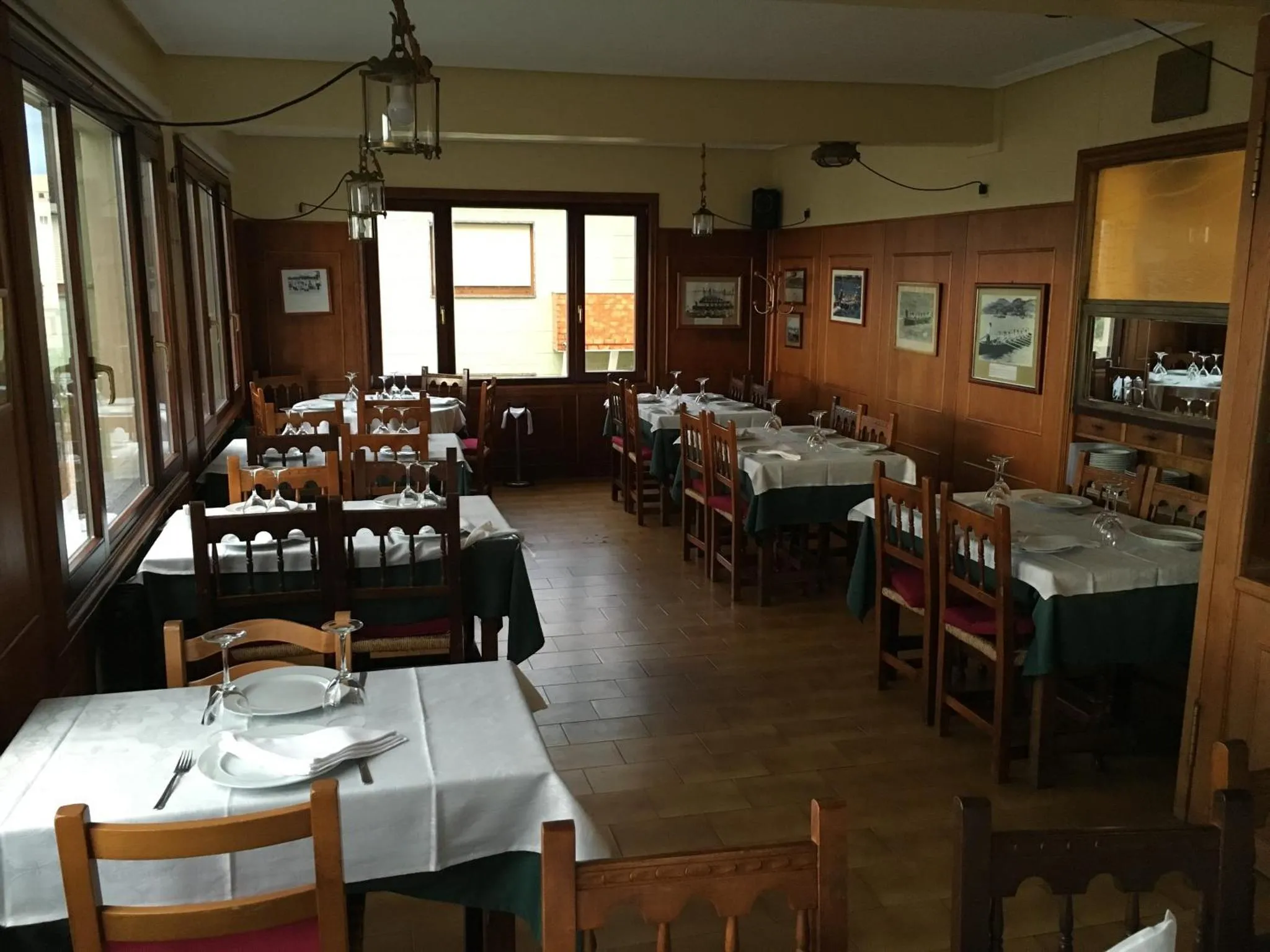 Une salle lumineuse avec des tables dressées pour un repas.
