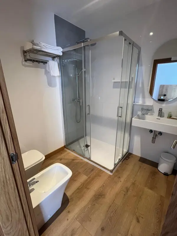 Une salle de bain moderne avec douche vitrée et sanitaires.