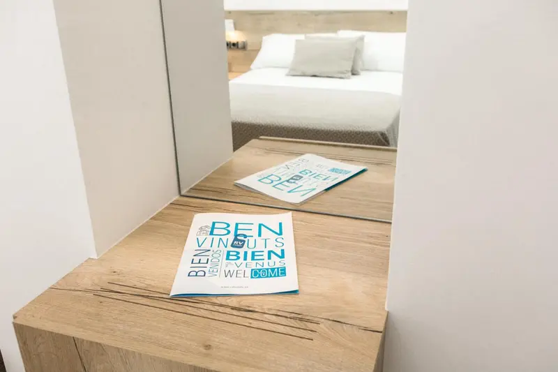 Une chambre lumineuse avec un bureau en bois et un grand miroir.